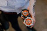 Barber Jody from History Barbershop in Barrie Ontario, holding both the King Brown Premium Pomade, and Cream Pomade in one grasp. Both tins have a stricking orange and white embossed lid of the King Brown Pomade insignia. Proudly formulated and hand poured in Australia. 